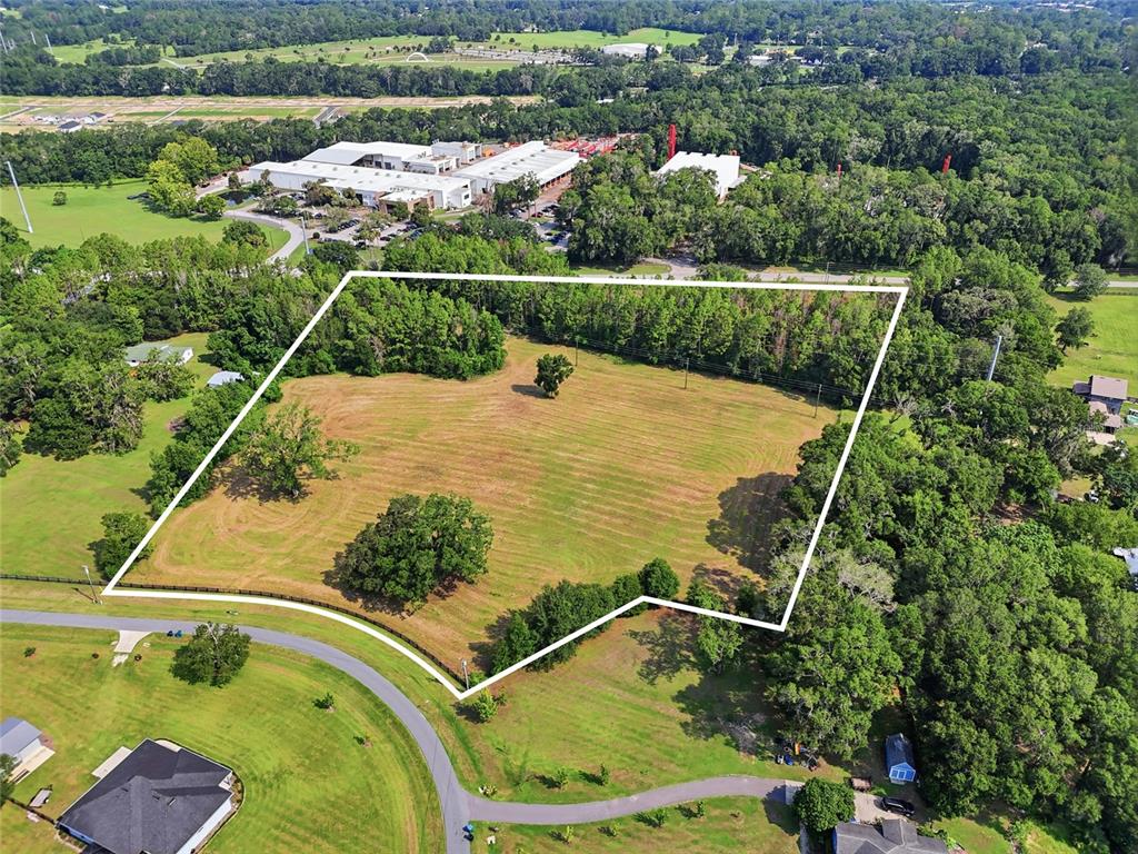 An aerial view shows a large, grassy, rectangular plot of land outlined in white — 14502 NW 132ND PLACE, ALACHUA, FL