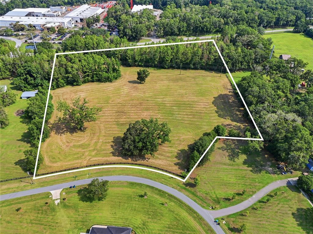 An aerial view shows a large, grassy, partially wooded plot of land outlined in white — 14502 NW 132ND PLACE, ALACHUA, FL