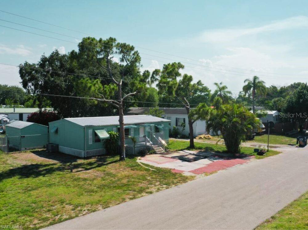 A light green mobile home with a front porch sits on a grassy lot — 1281 RICHMOND AVENUE, CLEWISTON, FL