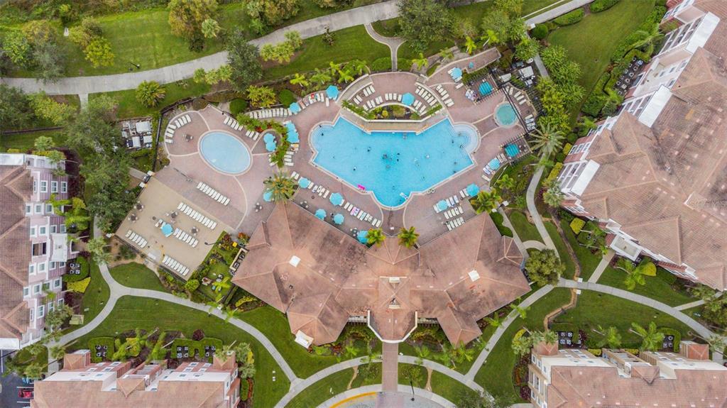 An aerial view of an apartment complex featuring a large swimming pool and clubhouse — 4001 BREAKVIEW DRIVE UNIT D409, ORLANDO, FL