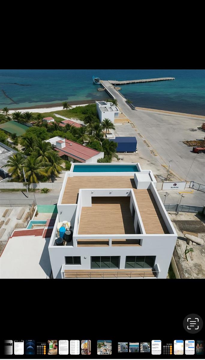 An aerial view shows a modern white building with a rooftop deck and swimming pool — 14 Rafael Megar # 306, MS, MS