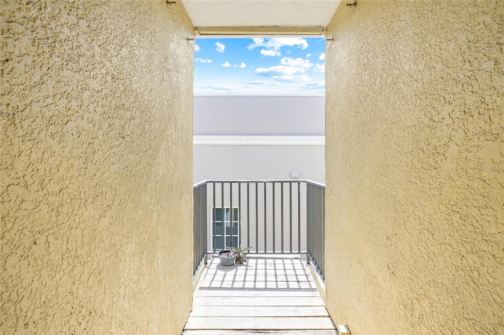 A view from a doorway looking out onto a small balcony with metal railings — 3206 W AZEELE STREET UNIT 227, TAMPA, FL