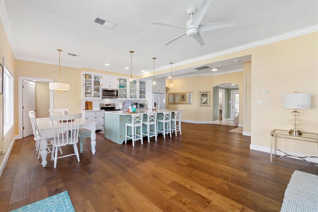 A kitchen with a light blue island, white cabinets, and a dining area on hardwood floors — 1426 RIVERSIDE DRIVE, DAYTONA BEACH, FL