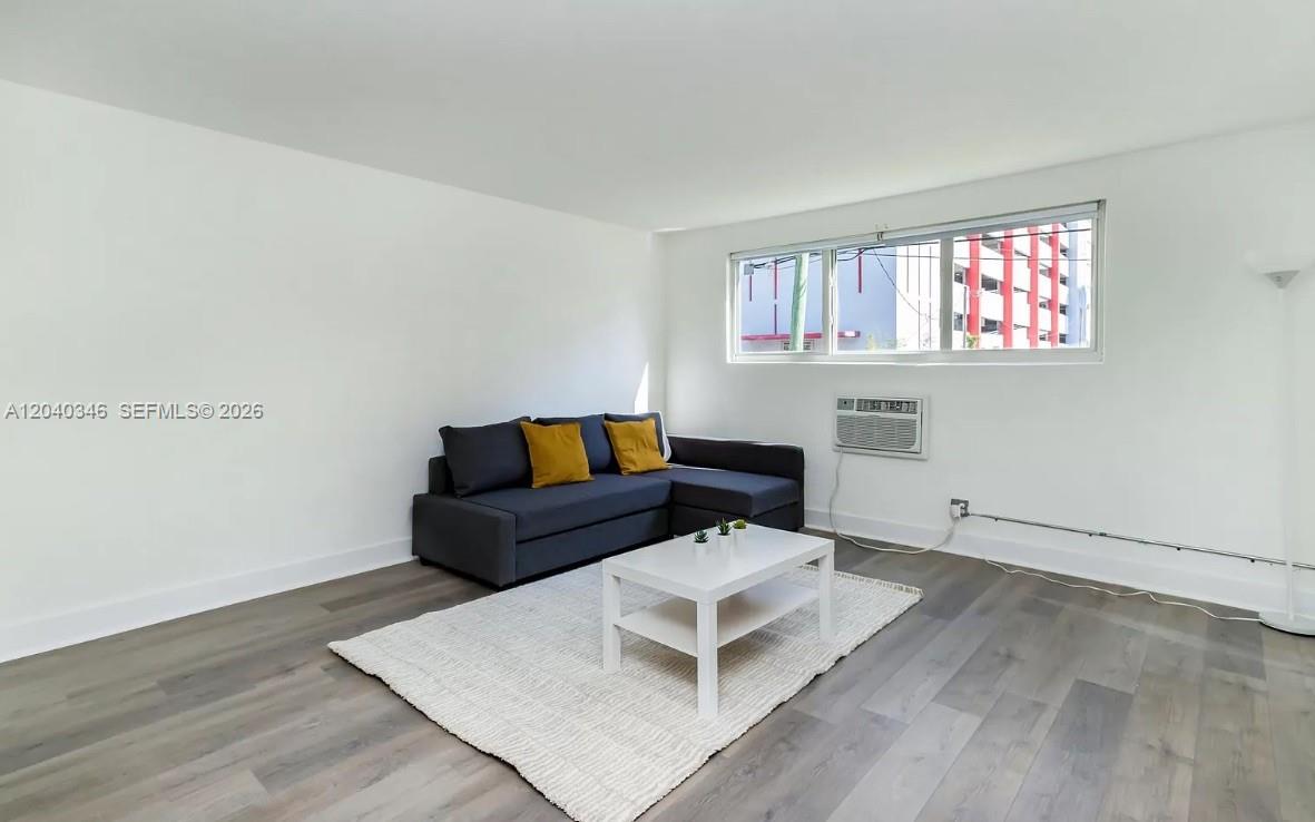 A living room features a gray sectional sofa, white coffee table, and light wood flooring — 143 SW 9th St # 301, Miami FL 33130, MIAMI, FL