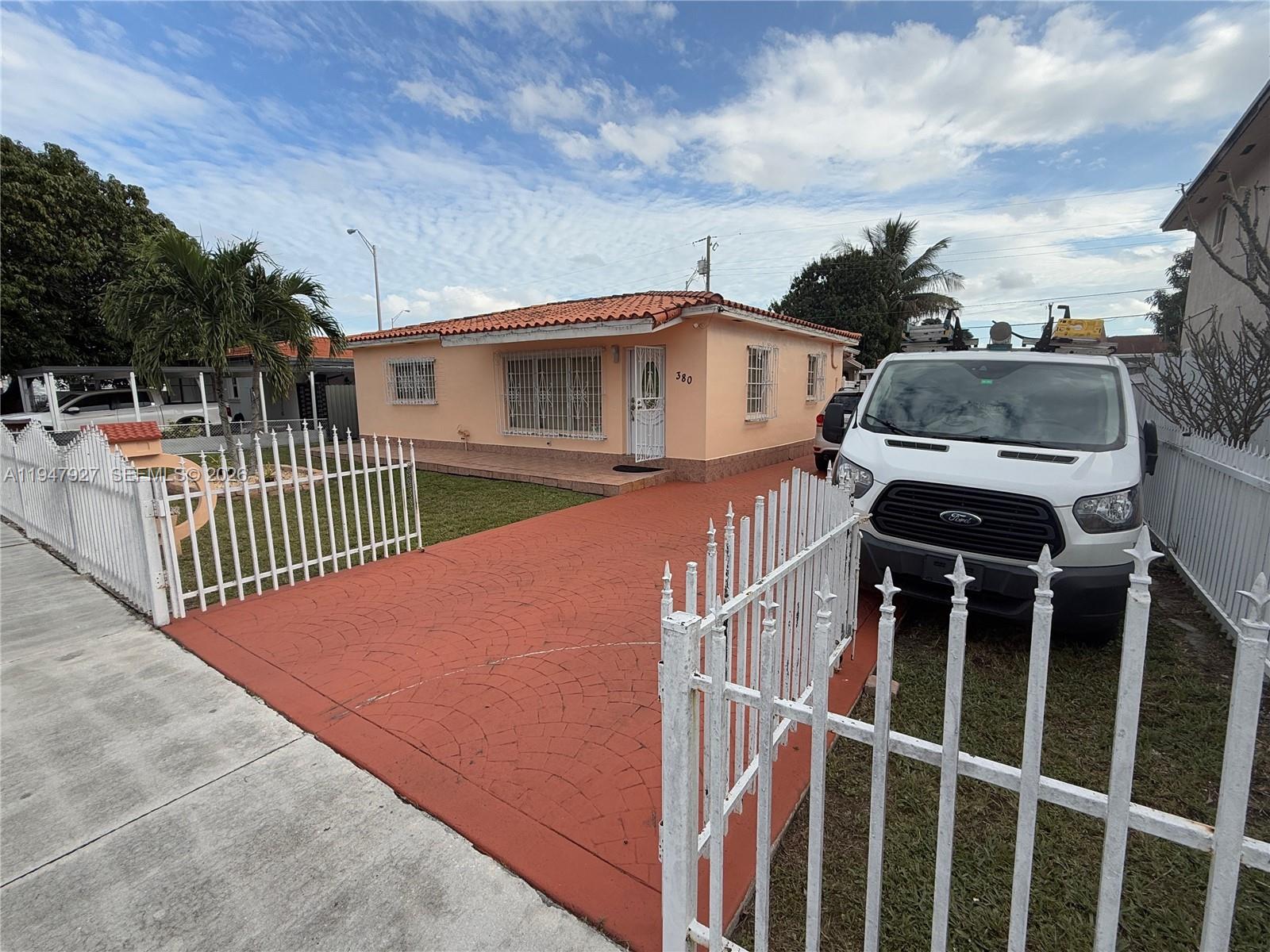 A single-story peach-colored house with a red tile roof and a white metal fence — 380 W 41st St, Hialeah FL 33012, HIALEAH, FL