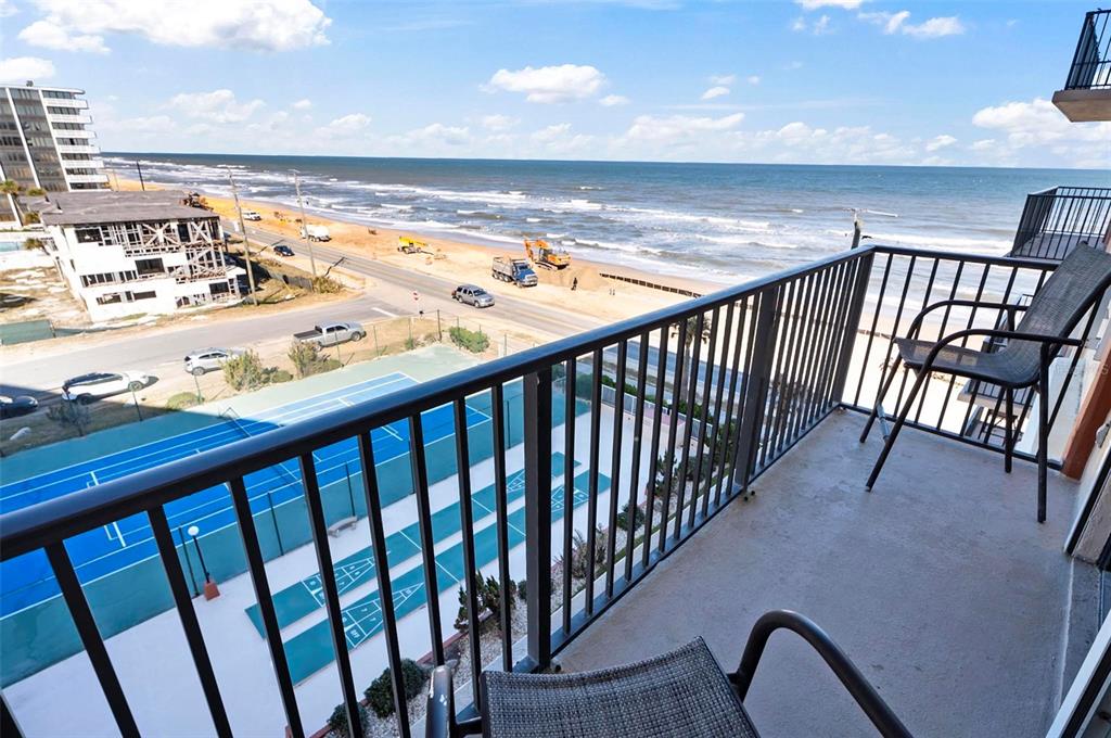 A balcony view overlooks a tennis court, a coastal road, and the ocean — 3600 S OCEAN SHORE BOULEVARD UNIT 614, FLAGLER BEACH, FL