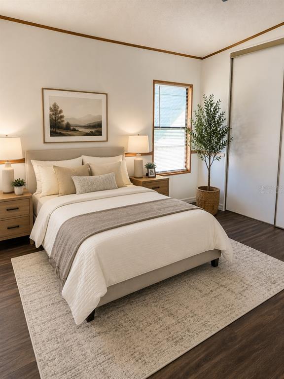 A bedroom features a bed with neutral bedding, two nightstands, a window, and a potted plant — 1990 CRYSTAL LANE, ST CLOUD, FL