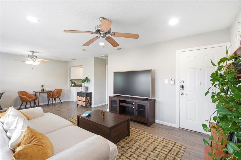 A living room features a white sofa, a television on a stand, and a dining area — 4725 COQUINA KEY DRIVE SE UNIT D, ST PETERSBURG, FL
