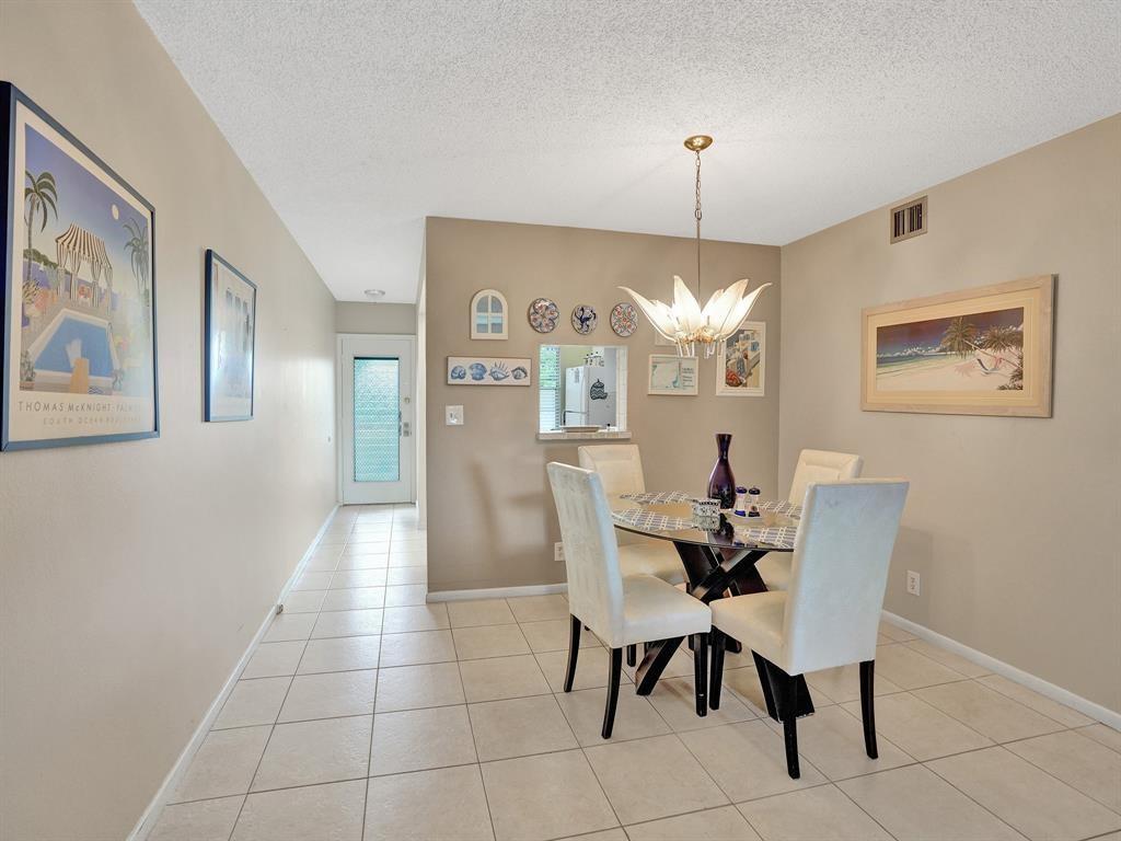 A dining area features a glass-topped table, four upholstered chairs, and tiled flooring — 2003 Granada Drive # C4, Coconut Creek FL 33066, COCONUT CREEK, FL
