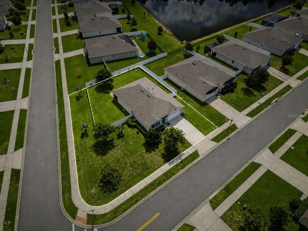 An aerial view shows a single-story house on a corner lot with a fenced backyard — 117 RIP CORD LANE, DELAND, FL
