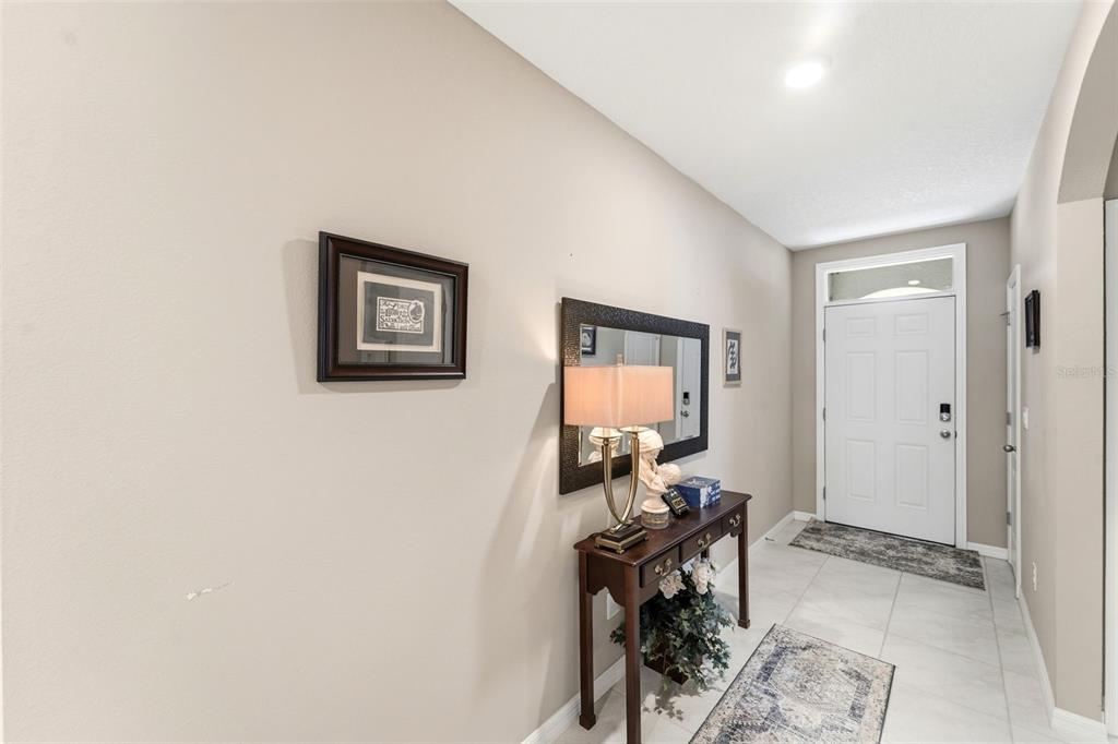 An entryway features a console table with a lamp and mirror against a beige wall — 117 RIP CORD LANE, DELAND, FL