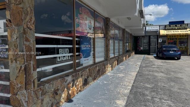 A stone-faced commercial building exterior features large glass windows and a nearby parked blue car — 4021 NW 7th St # 5, Miami FL 33126, MIAMI, FL