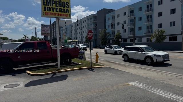 A red pickup truck is parked in front of a commercial sign and apartment building — 4021 NW 7th St # 5, Miami FL 33126, MIAMI, FL