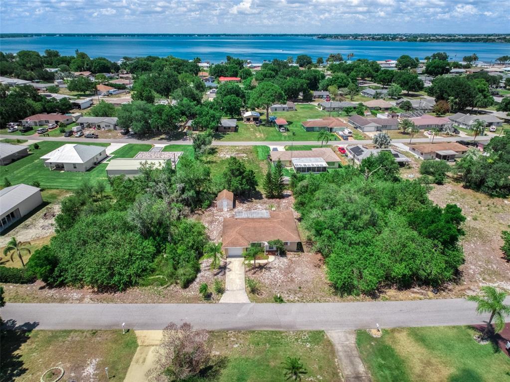 An aerial view shows a single-story house with a brown roof surrounded by trees — 111 LEMON ROAD NW, LAKE PLACID, FL