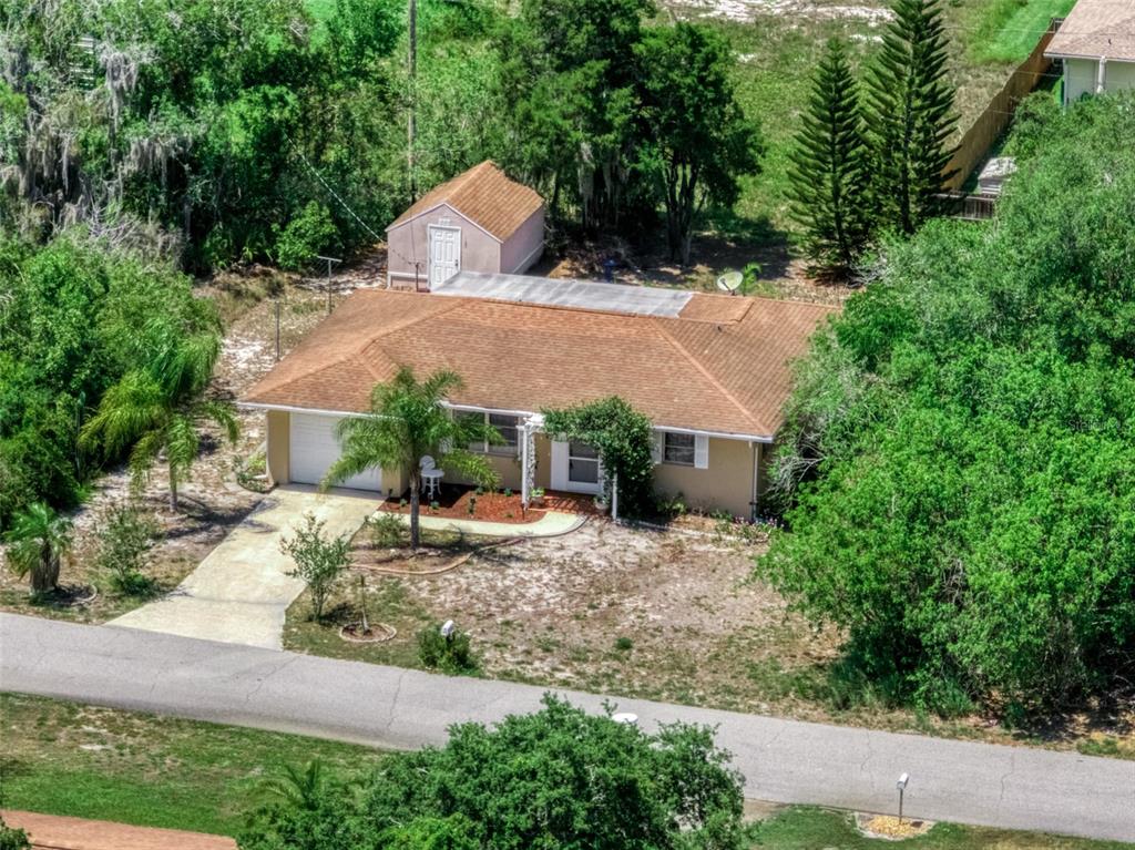 An aerial view shows a single-story house with a brown roof and a detached shed — 111 LEMON ROAD NW, LAKE PLACID, FL