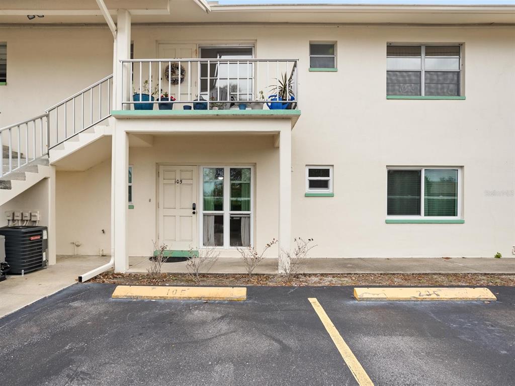 The exterior of a two-story apartment building features a ground-level unit, a balcony, and parking — 8303 BARDMOOR BOULEVARD UNIT 105, SEMINOLE, FL