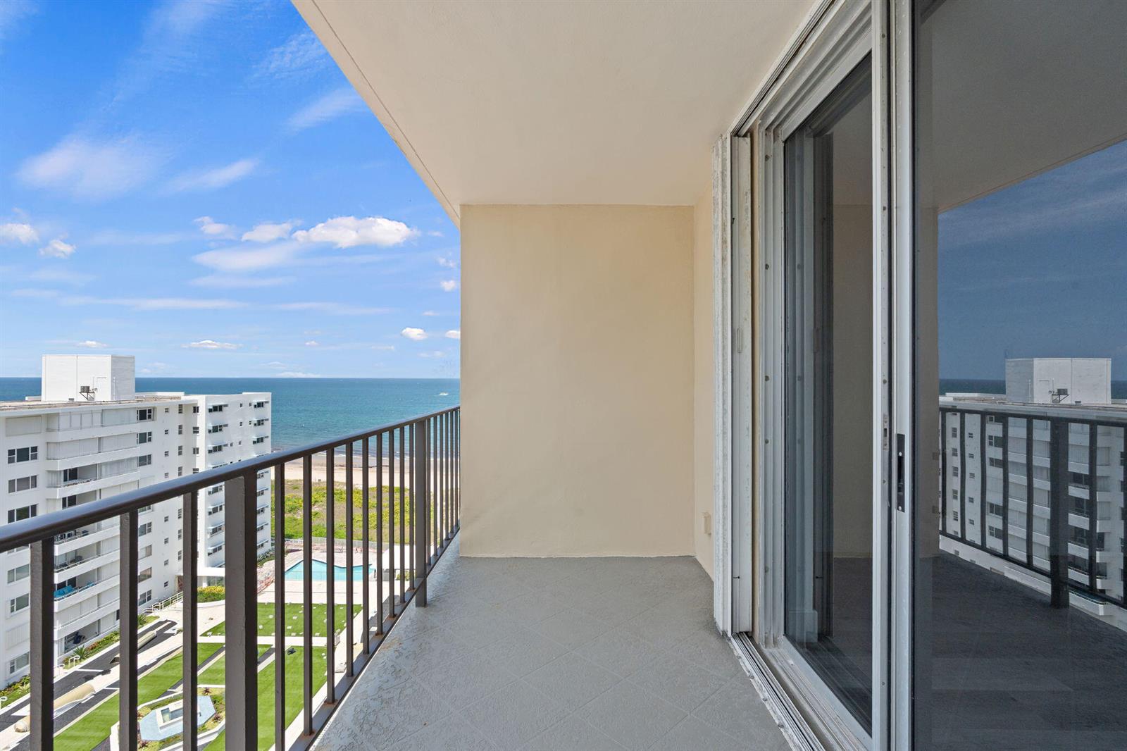 A balcony with a gray tiled floor, metal railing, and a view of the ocean — 1900 S Ocean Boulevard # 10j, Pompano Beach FL 33062, POMPANO BEACH, FL