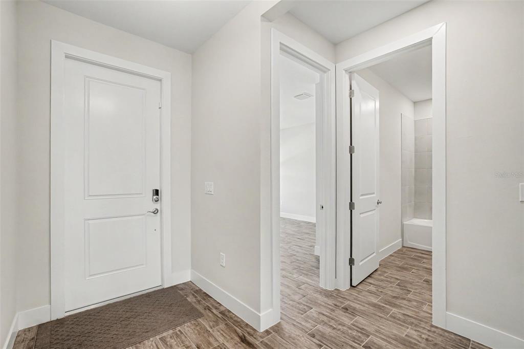 An interior view of a home entryway with a white door and two open doorways — 44353 PANTHER DRIVE, PUNTA GORDA, FL