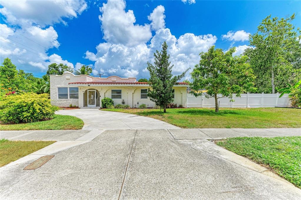 A single-story house with a stucco exterior, red tile roof, and a concrete driveway — 1712 4TH STREET W, PALMETTO, FL