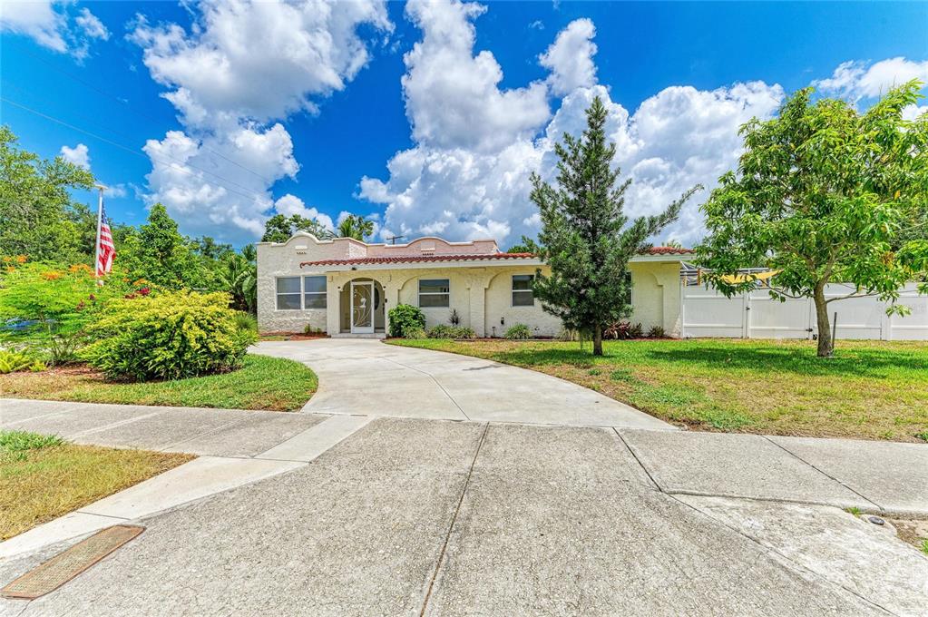 A single-story stucco house with a curved roofline and a concrete driveway — 1712 4TH STREET W, PALMETTO, FL