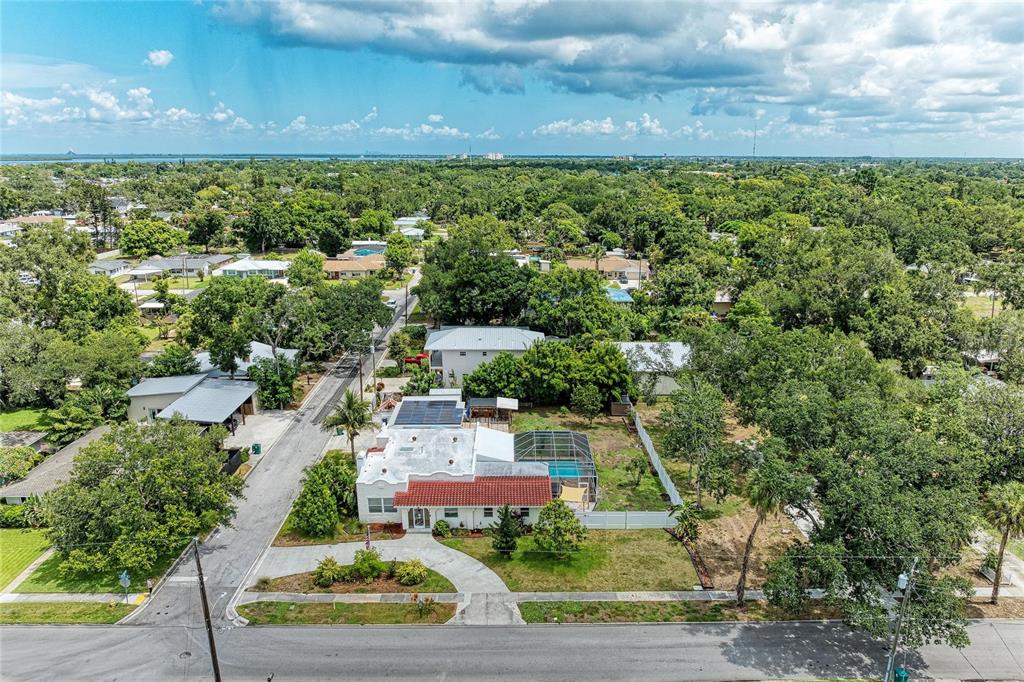 An aerial view shows a single-story house with a red tile roof and pool enclosure — 1712 4TH STREET W, PALMETTO, FL