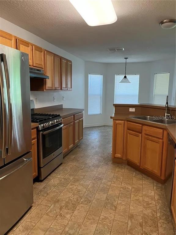 A kitchen features wood cabinets, stainless steel appliances, and a breakfast nook with bay windows — 8714 SW 83RD LOOP, OCALA, FL