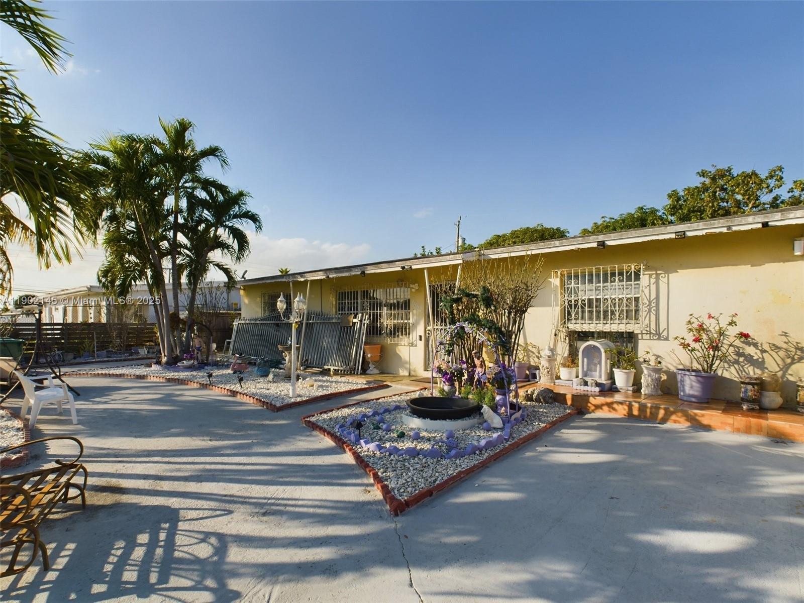A single-story house with a concrete driveway, landscaped rock beds, and palm trees — 3861 NW 177th St, Miami Gardens FL 33055, MIAMI GARDENS, FL