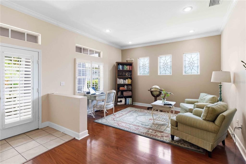 A home office and sitting area with hardwood floors, a bookshelf, and two armchairs — 16817 HARRIERRIDGE PLACE, LITHIA, FL