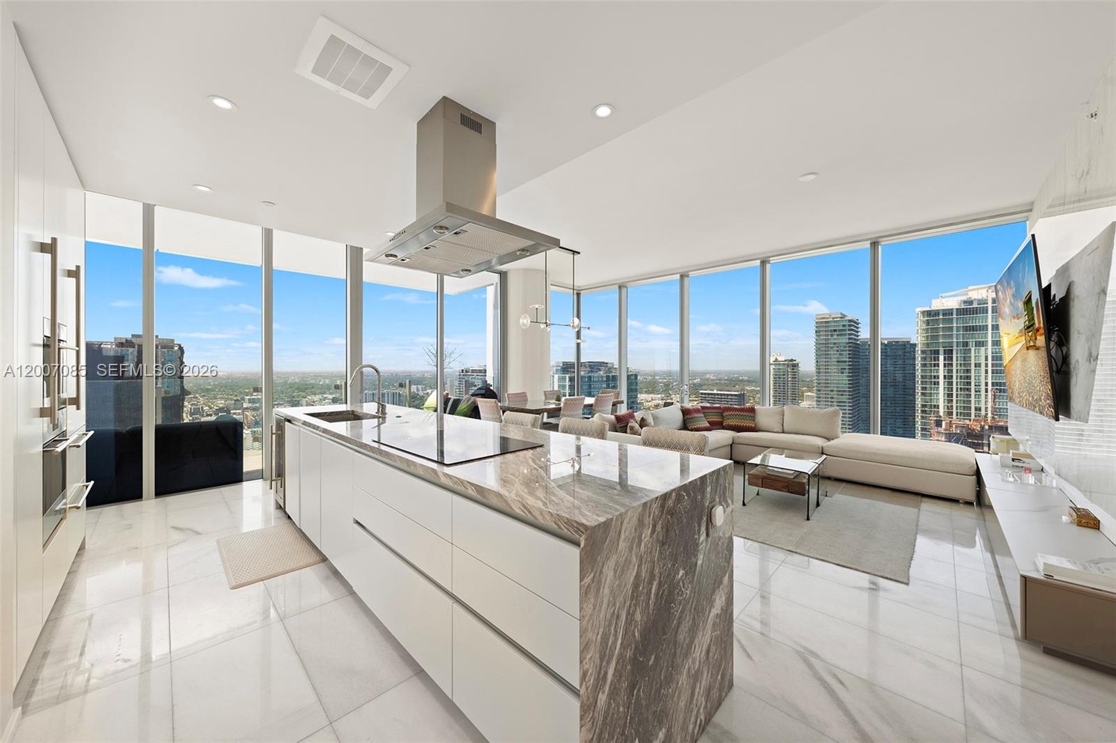 A modern open-concept kitchen and living area features a marble island and floor-to-ceiling windows — 700 NE 26th Ter # 4206, Miami FL 33137, MIAMI, FL
