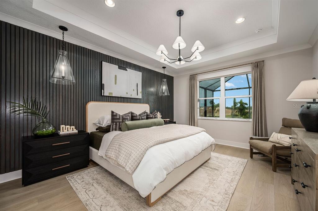 A bedroom features a dark slatted accent wall, a central chandelier, and a large window — 13694 LOREDO WAY, PUNTA GORDA, FL
