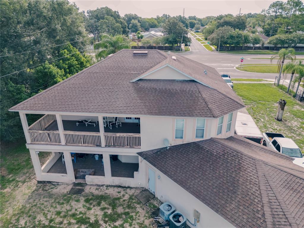 An elevated two-story house with a wrap-around porch and a brown shingled roof — 2266 RED GATE ROAD, ORLANDO, FL