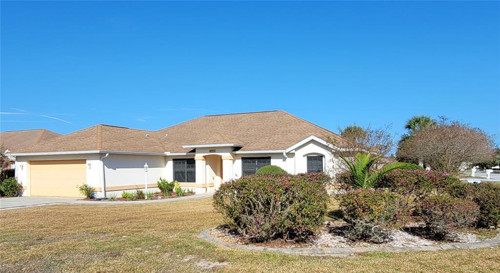 A single-story house with a tan exterior, a brown shingled roof, and a two-car garage — 4773 NW 32ND STREET, OCALA, FL
