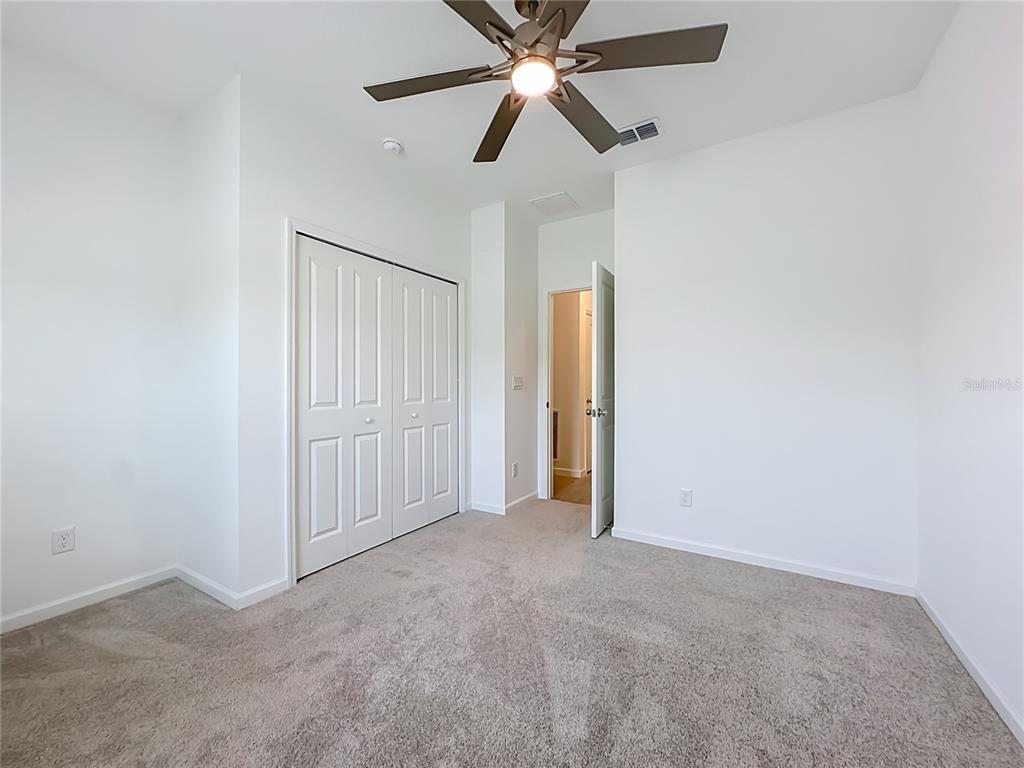 A bedroom with white walls, gray carpet, a ceiling fan, and a closet — 3153 TUPELO LOOP, GREEN COVE SPRINGS, FL