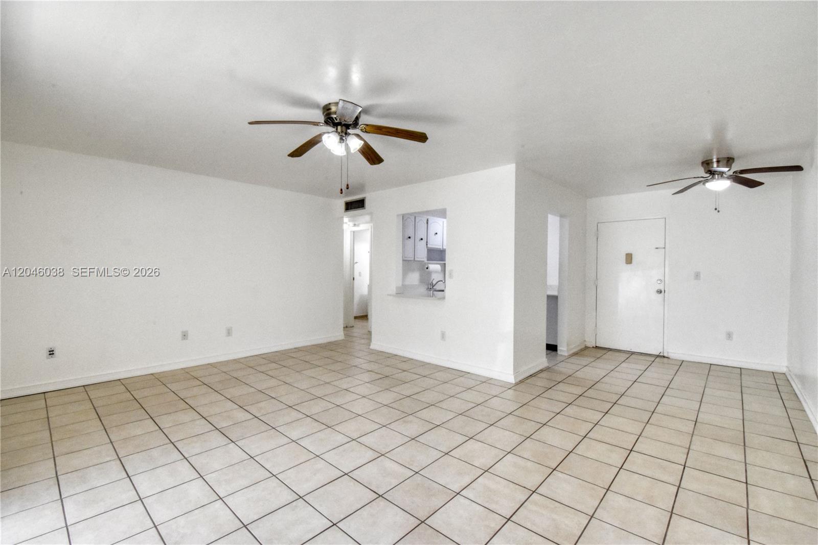 An open living area features white walls, tiled floors, and two ceiling fans — 10387 N Kendall Dr # R2, Miami FL 33176, MIAMI, FL