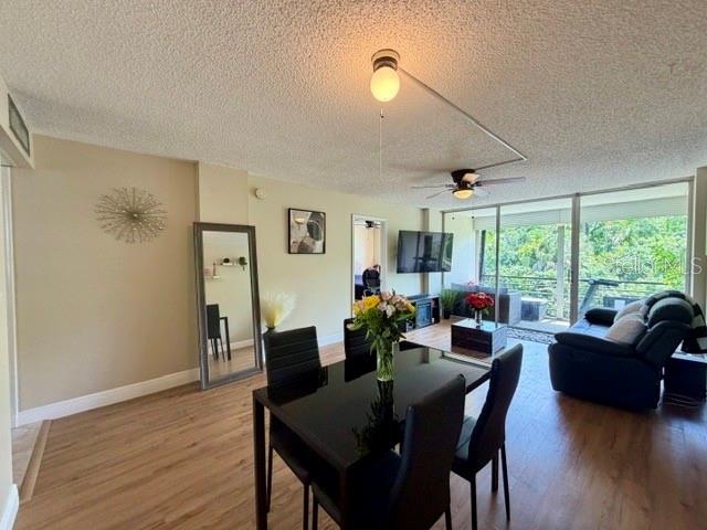 A dining area with a black table and chairs opens into a living room — 107 ROYAL PARK DRIVE UNIT 2G, OAKLAND PARK, FL