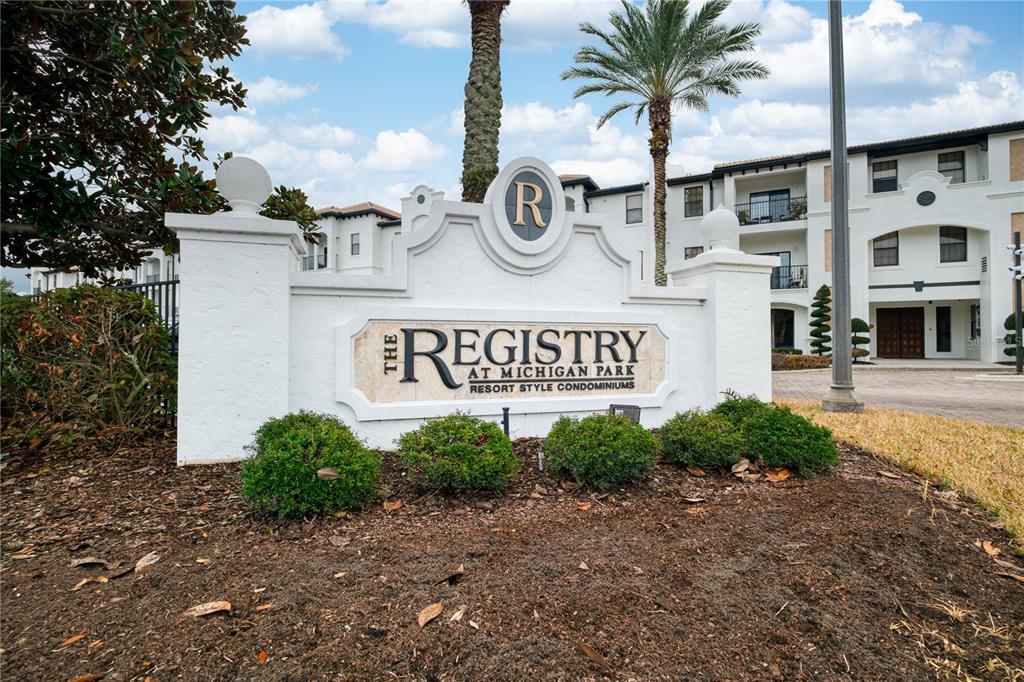 A white monument sign for The Registry at Michigan Park stands before a condominium building — 5550 E MICHIGAN STREET UNIT 3306, ORLANDO, FL