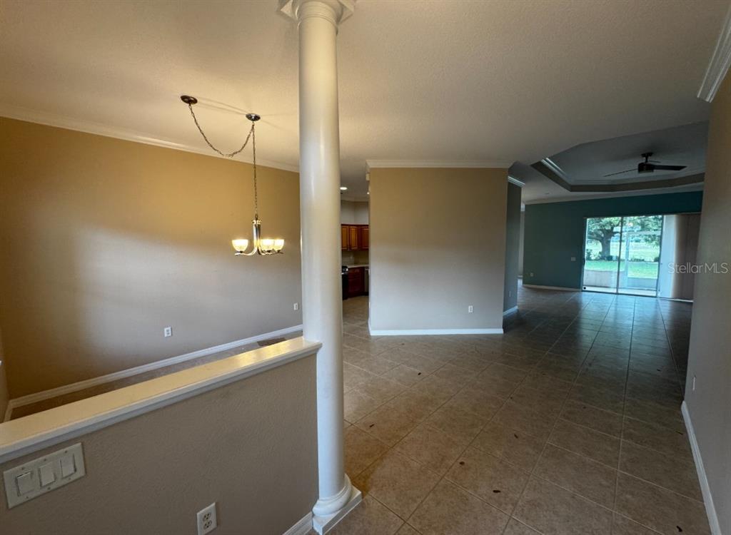 A spacious open-concept living area features a central white column, tile flooring, and neutral walls — 8821 SW 82ND COURT ROAD, OCALA, FL