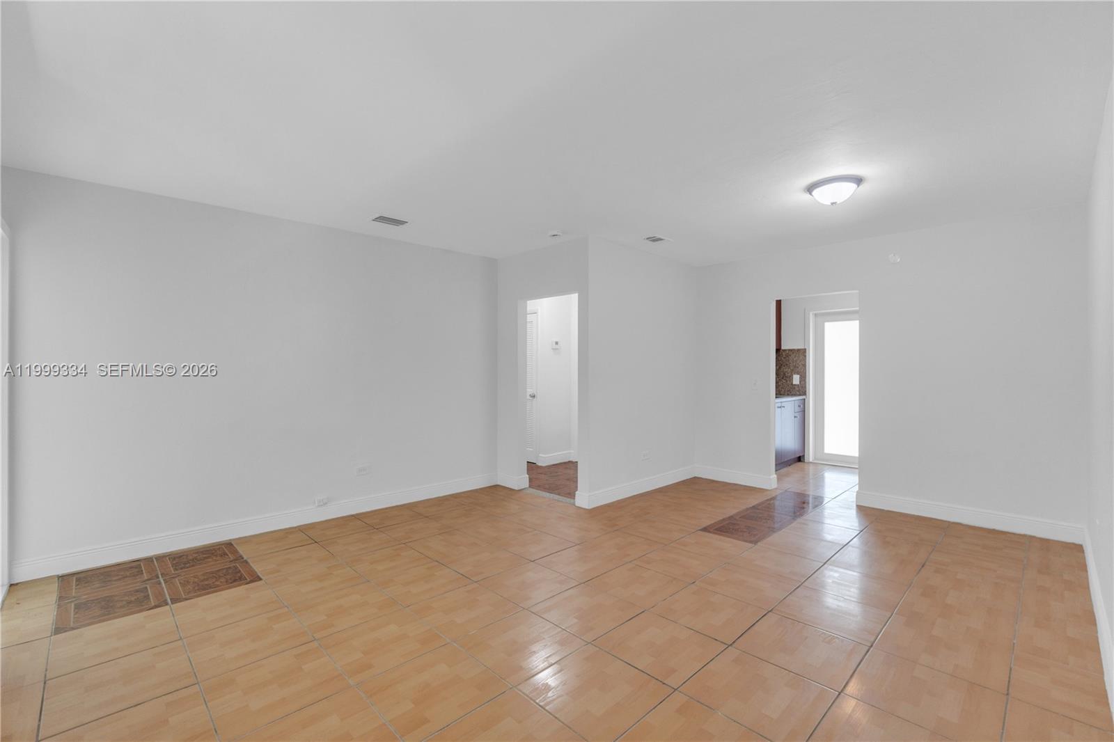 An empty room features light-colored tile flooring, white walls, and two doorways — 1730 NW 55th Ter # 1730, Miami FL 33142, MIAMI, FL