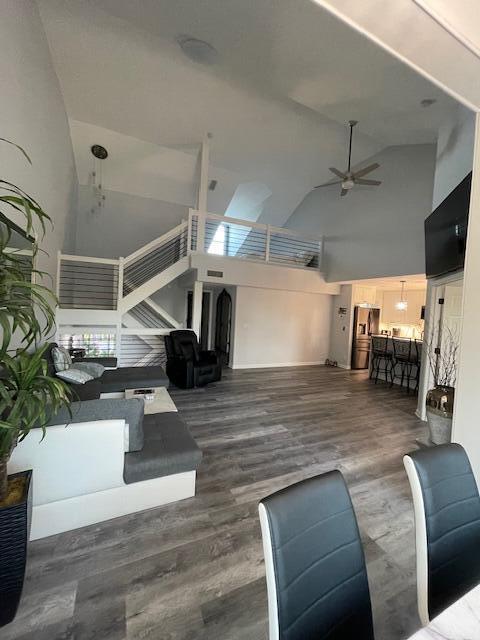 A living room with gray wood flooring, a staircase with cable railings, and a loft — 3602 Fairway Drive N, Jupiter FL 33477, JUPITER, FL