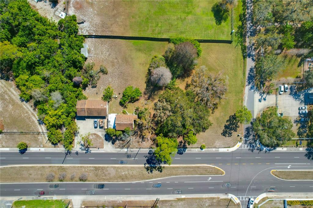 An aerial view shows a house and detached garage on a large, tree-filled lot — 12750 PARK BOULEVARD, SEMINOLE, FL