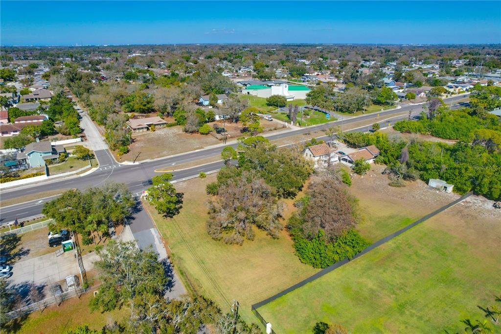 An aerial view shows a large grassy lot with trees, a house, and a road — 12750 PARK BOULEVARD, SEMINOLE, FL