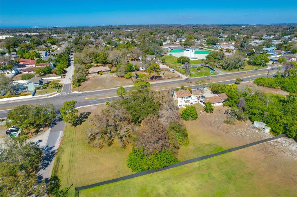 An aerial view shows a large grassy lot with trees, a house, and nearby roads — 12750 PARK BOULEVARD, SEMINOLE, FL