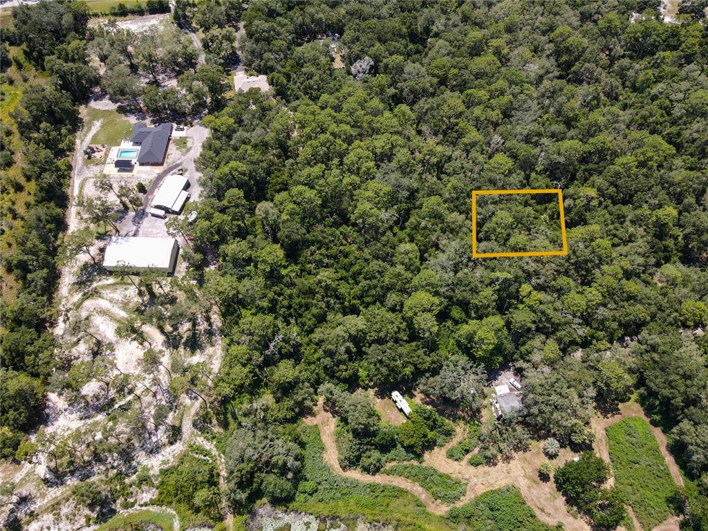 An aerial view shows a wooded lot with a highlighted rectangular area and nearby buildings — BOSTON (PAPER) AVENUE, ORANGE CITY, FL