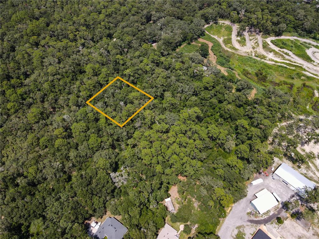 An aerial view shows a wooded lot outlined in yellow near existing residential properties — BOSTON (PAPER) AVENUE, ORANGE CITY, FL