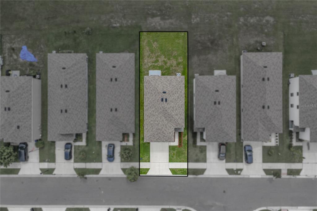 This aerial view shows a single-family home with a fenced backyard in a residential neighborhood — 13648 WHISKEY DAISY DRIVE, DADE CITY, FL