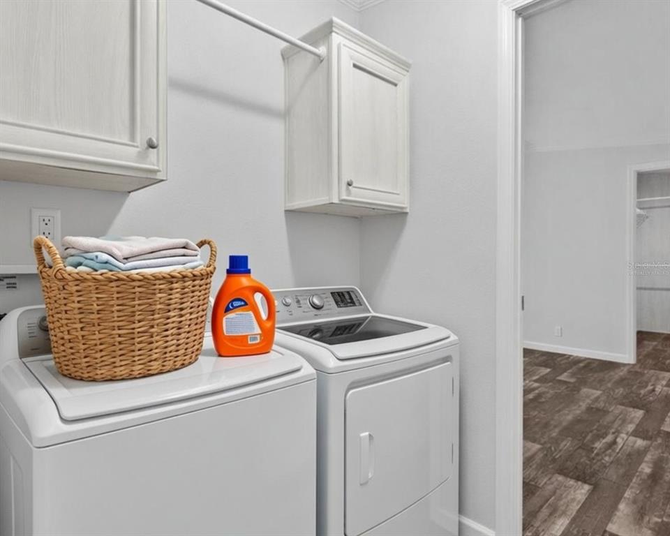 A laundry room with white cabinets, a wicker basket, and a washer and dryer set — 3035 CRYSTAL HILLS DRIVE, LAKELAND, FL