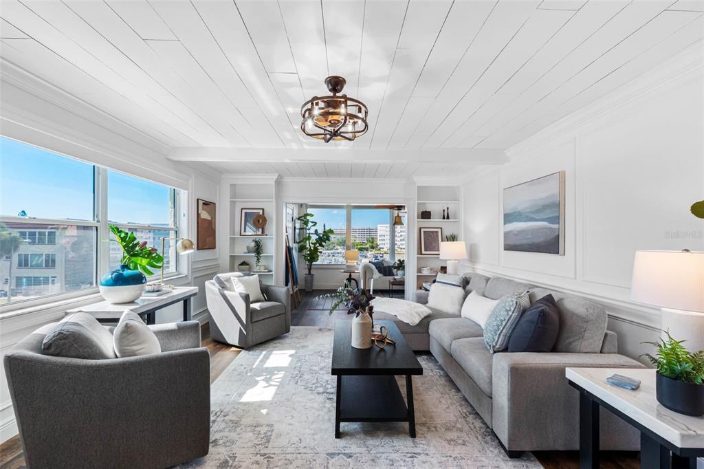A bright living room features a shiplap ceiling, gray sectional sofa, and large windows — 5940 30TH AVENUE S UNIT 301, GULFPORT, FL