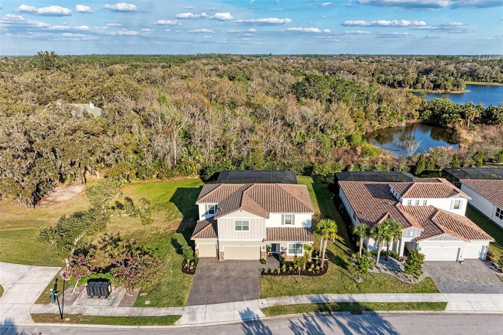 An aerial view shows two suburban houses with tile roofs and screened-in back patios — 7284 GREAT EGRET BOULEVARD, SARASOTA, FL