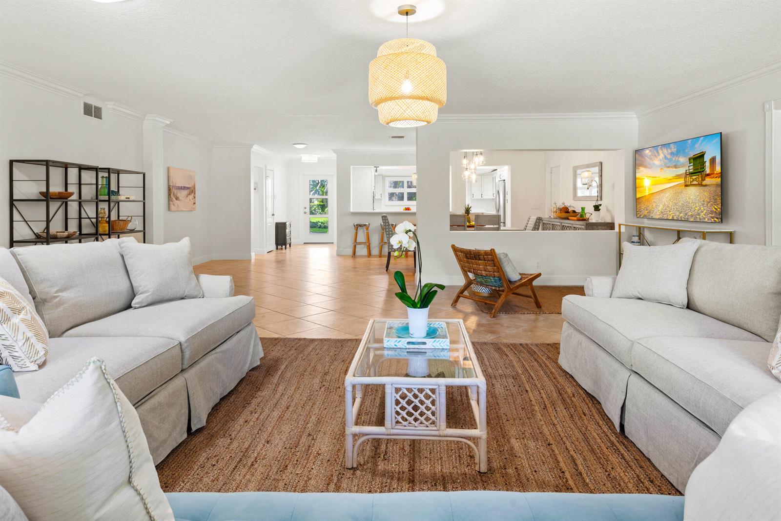 A bright living room features two light-colored sofas, a glass coffee table, and tile flooring — 602 N Atlantic Drive, Lantana FL 33460, LANTANA, FL