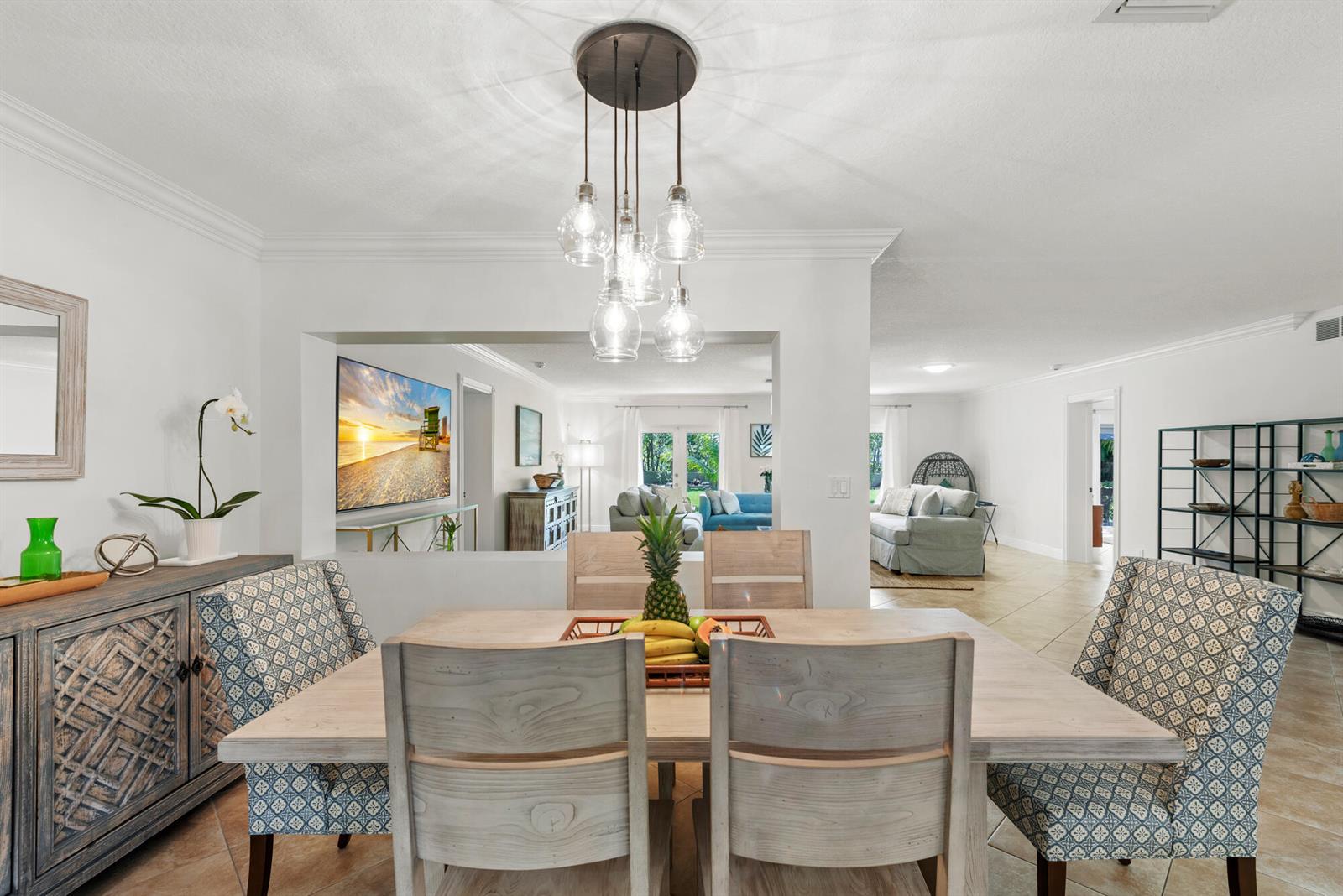 A dining room with a wooden table, patterned chairs, and a multi-pendant light fixture — 602 N Atlantic Drive, Lantana FL 33460, LANTANA, FL